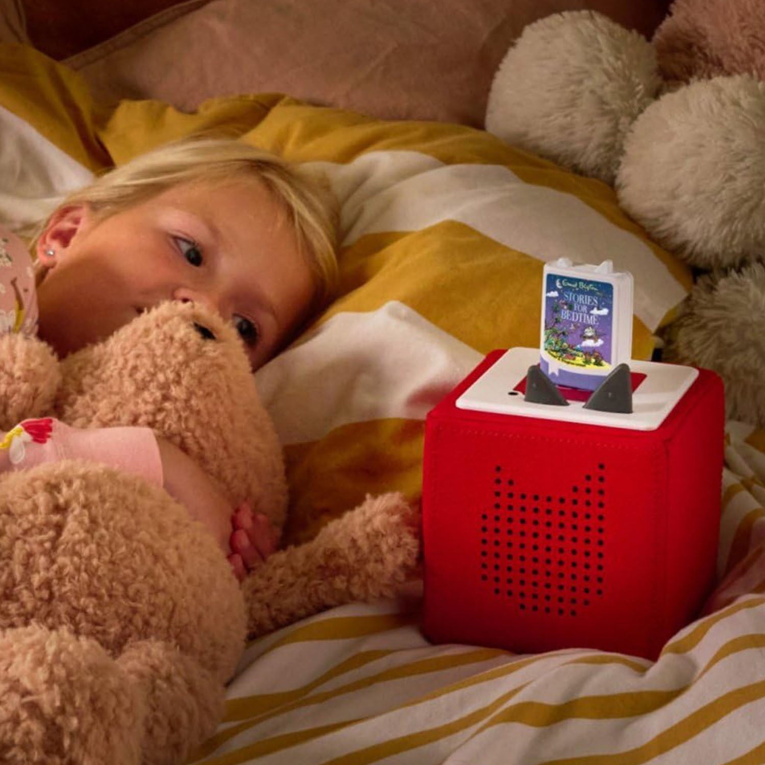 Children enjoying gentle and magical bedtime stories by placing the Tonie on a Toniebox and listening independently.