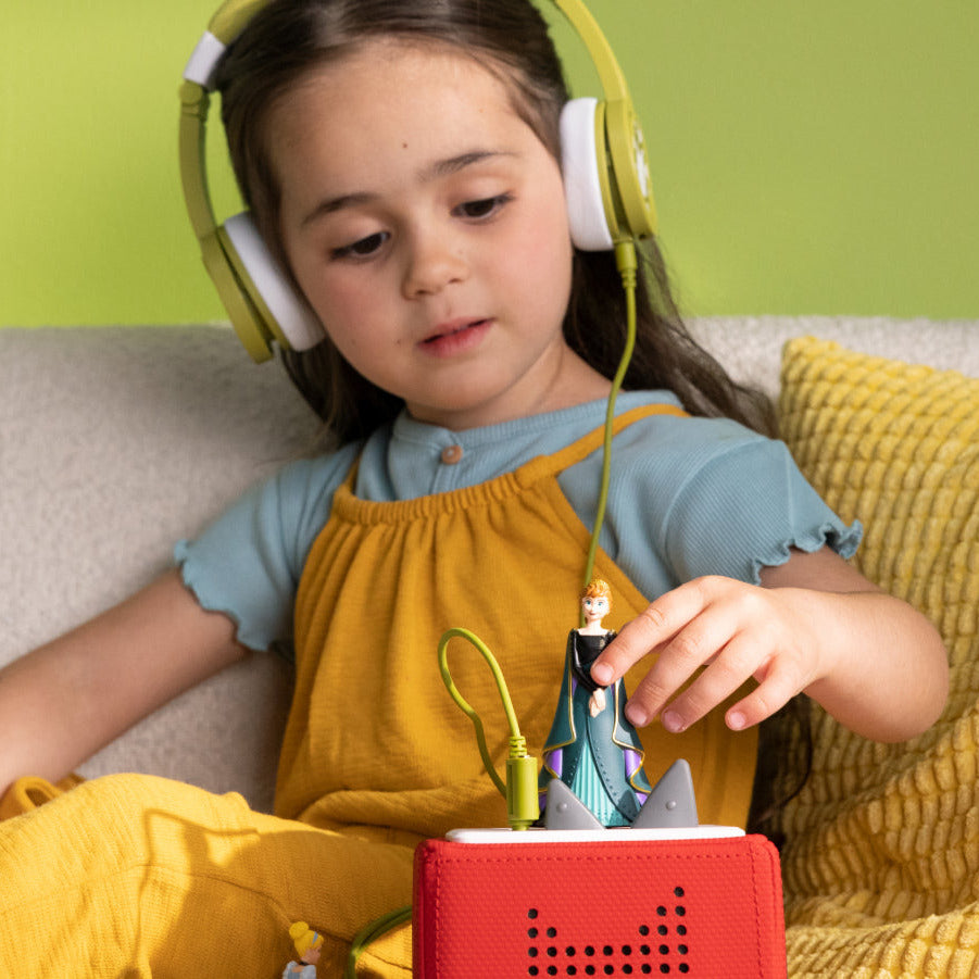Young girl listening to Frozen 2 Tonies story with Anna figurine.