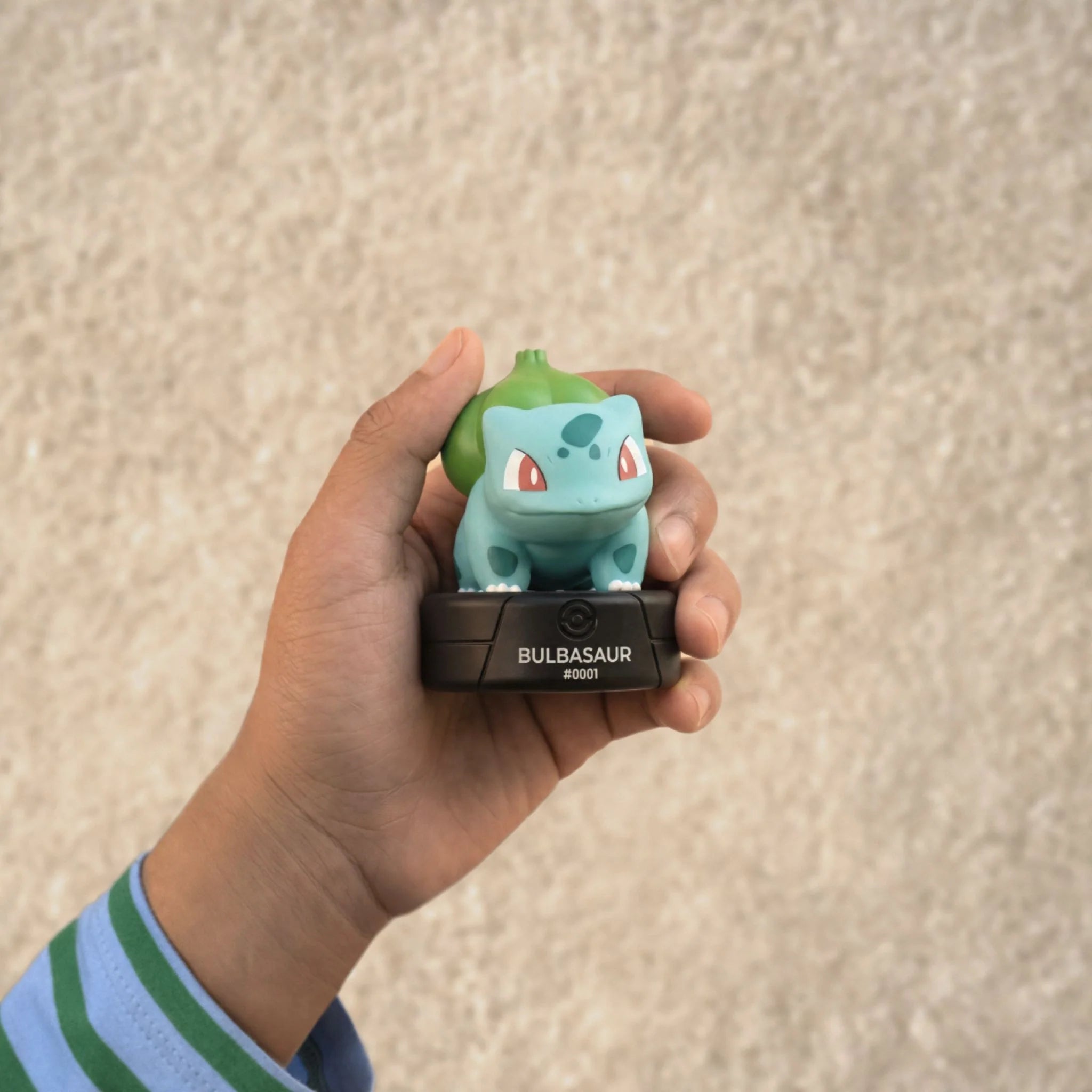 A kid is holding the tonies pokemon bulbasaur.