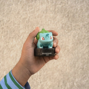 A kid is holding the tonies pokemon bulbasaur.