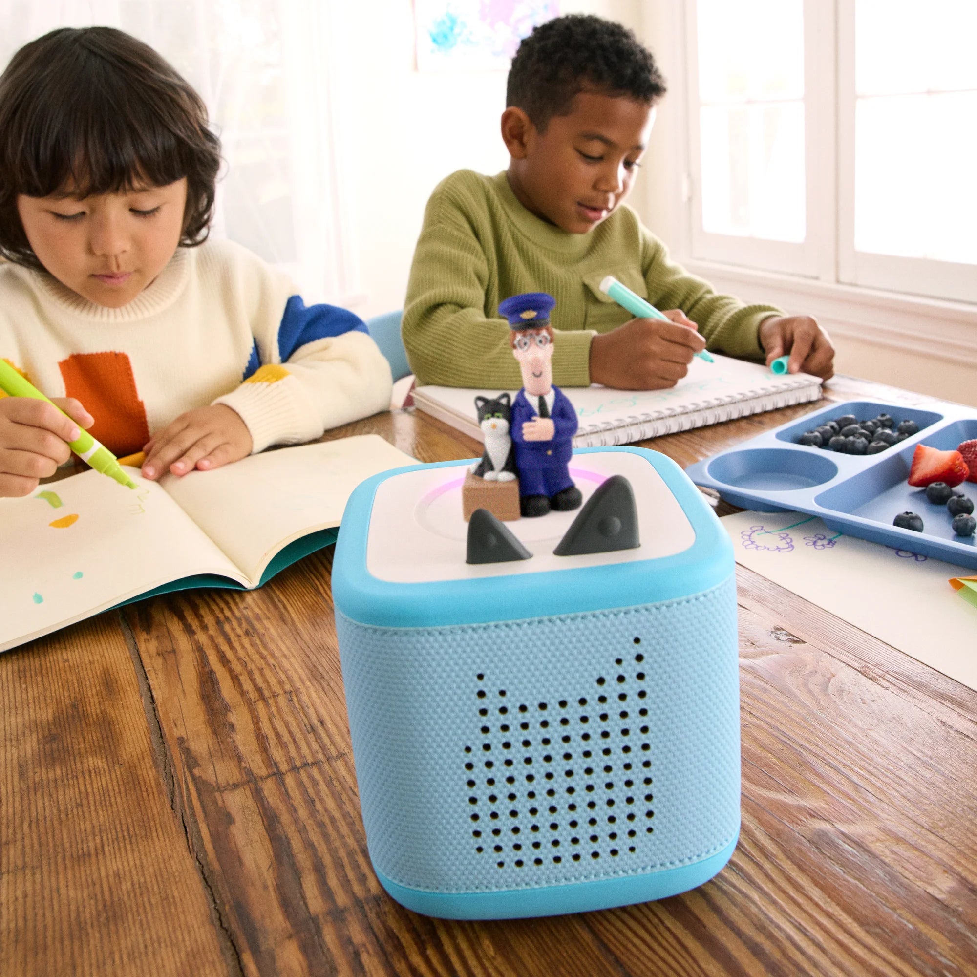 Bright Toniebox speaker cube with the Postman Pat Tonie placed on top ready to play