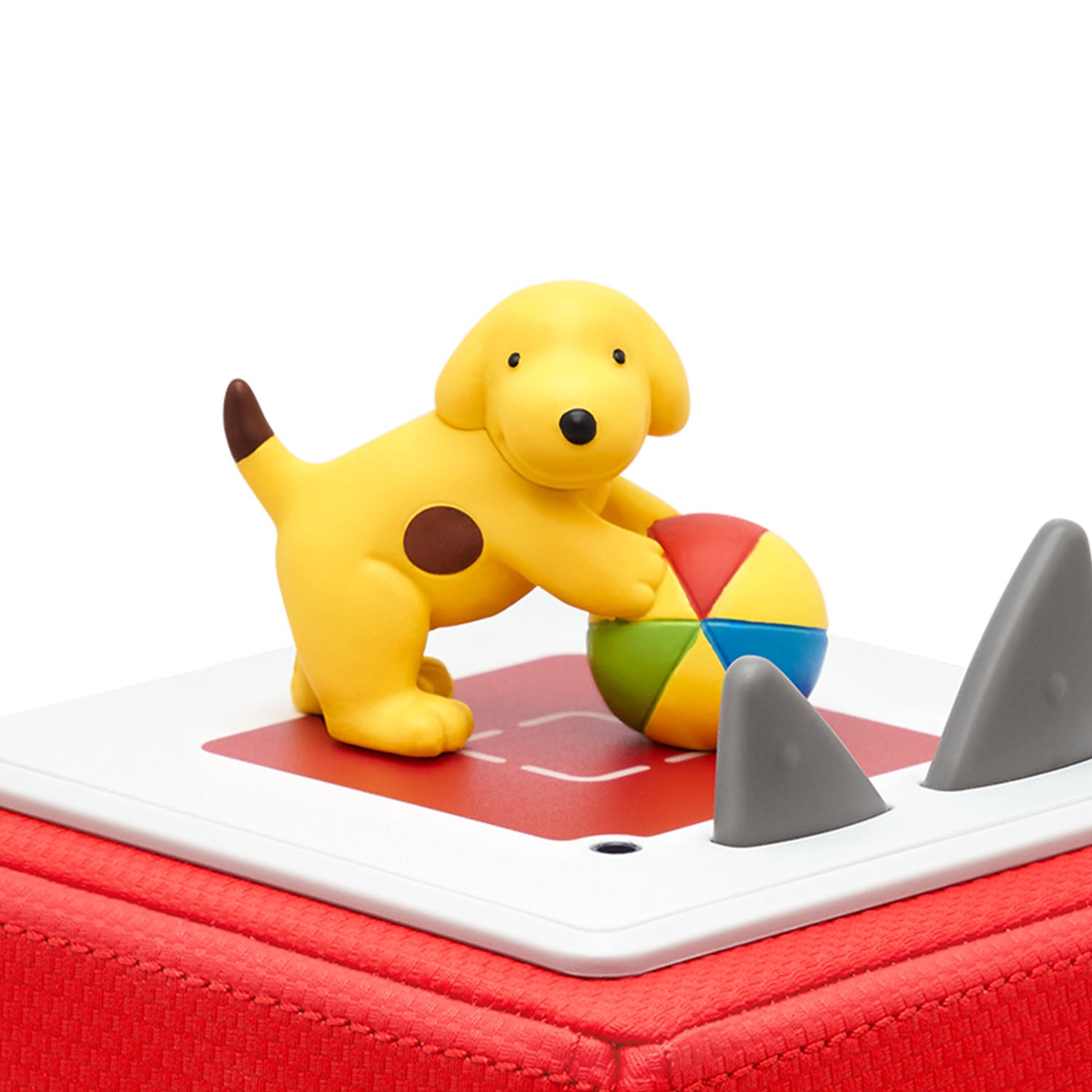 Spot the puppy standing playfully on a red Toniebox, ready to start the audio stories.