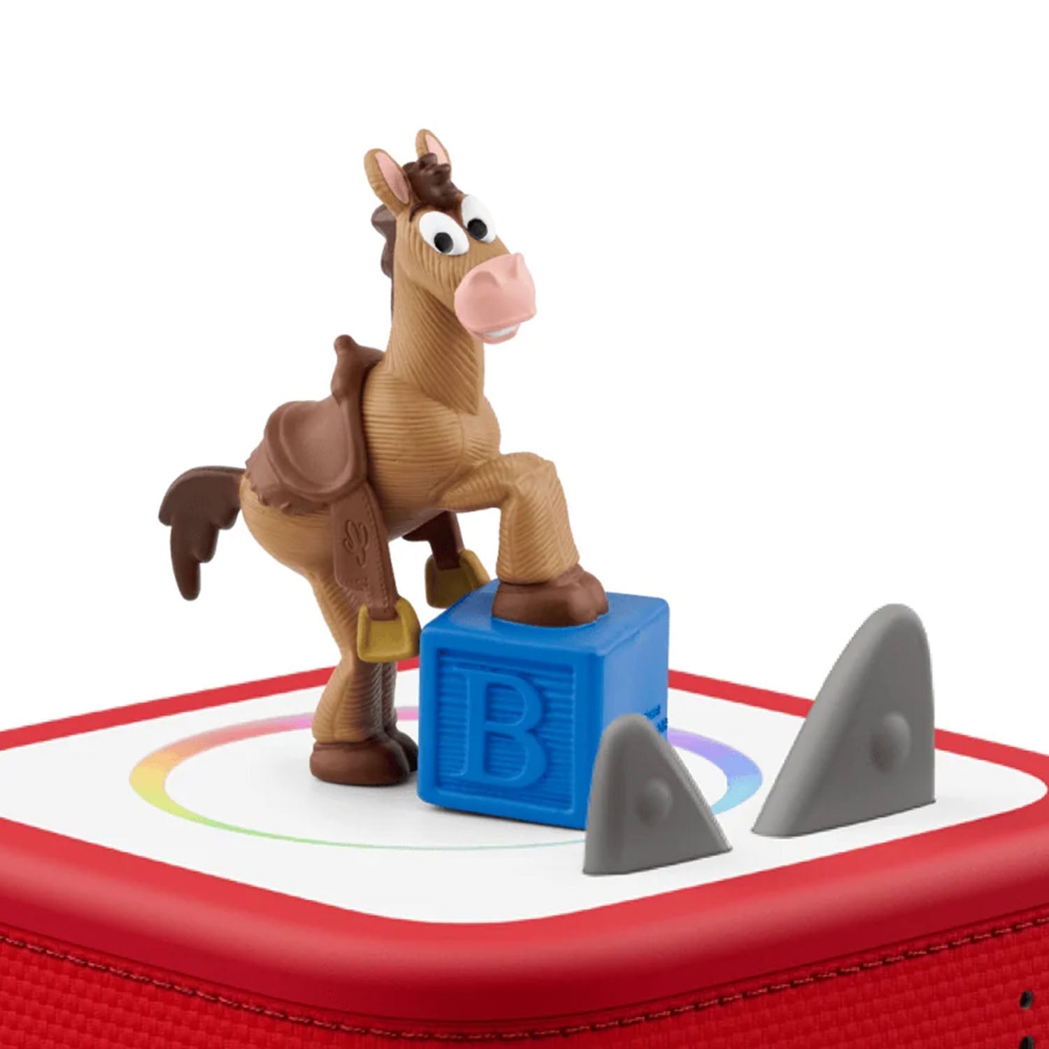 Tonies Toy Story 5 Bullseye audio figure placed magnetically on the red top surface of a Toniebox speaker to demonstrate how to start playing the audio story.