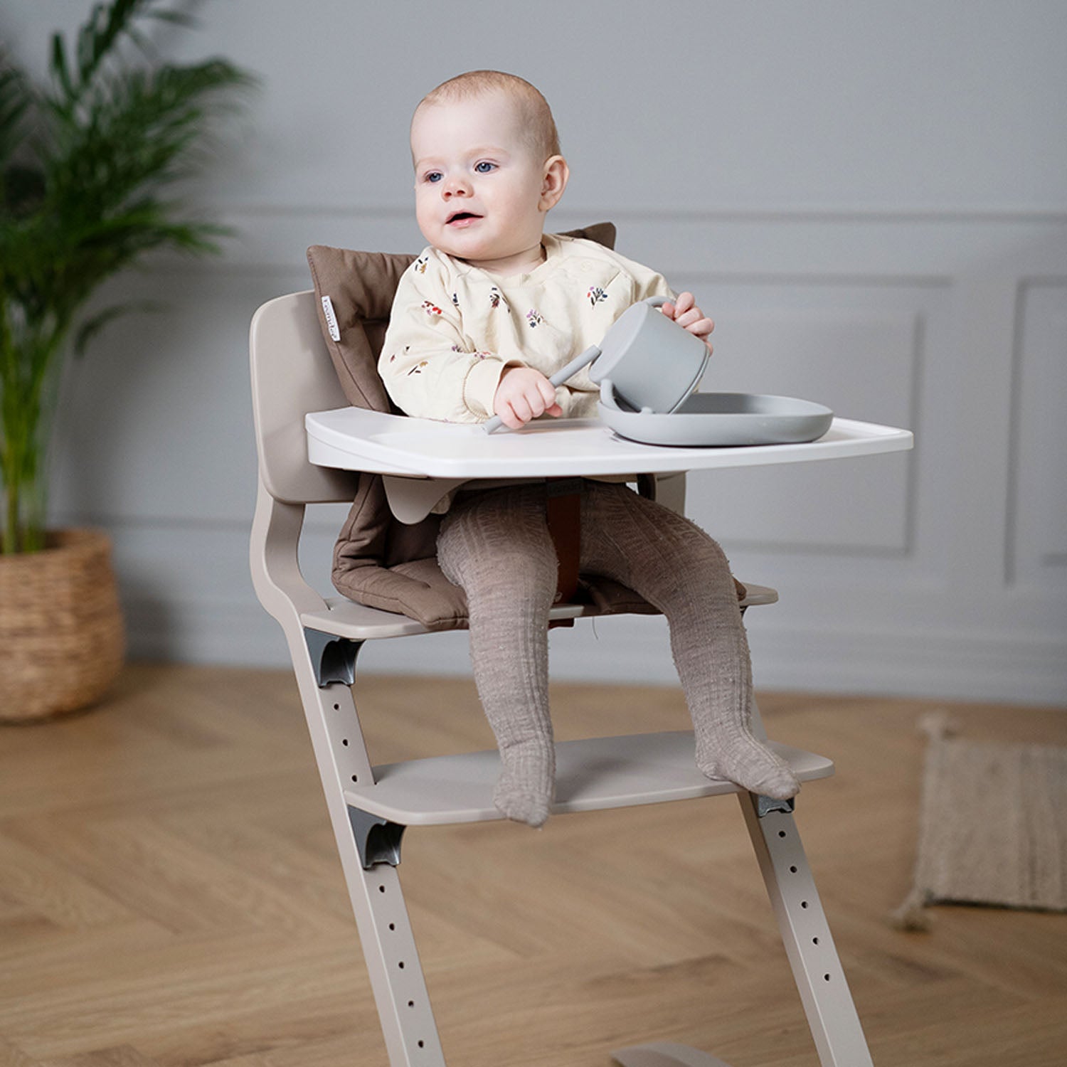 Tray positioned at child’s chest height, creating a stable surface for snacks, or toys