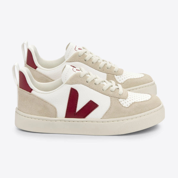Stylish white and marsala Veja V-10 sneakers ethically crafted with ChromeFree leather, recycled polyester lining, and an outsole made with Amazonian rubber. 