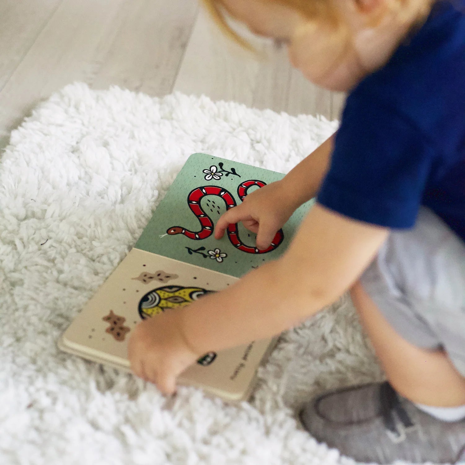 Wee Gallery Touch and Feel “Scales” book showing fish and snake with raised texture details