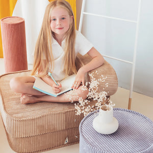 A girl is studying on the Wigiwama foldable chair.