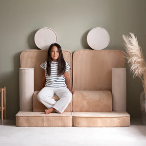 A girl is rearranging the Wigiwama sofa and sitting on them.