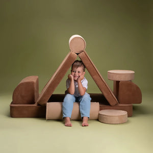 A boy is sitting on the modular sofa set.
