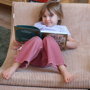 A toddler is sitting on the modular soft chair.