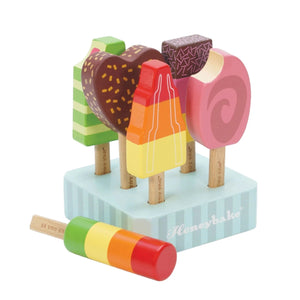 A set of colorful hand-painted wooden ice lollies displayed on a stand, resembling various flavors such as strawberry, chocolate, and vanilla.
