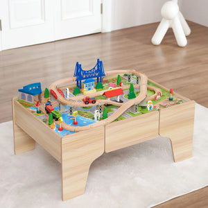 A wooden train set with a colorful locomotive, passenger cars, and cargo cars on a wooden track layout on a colorful rug.