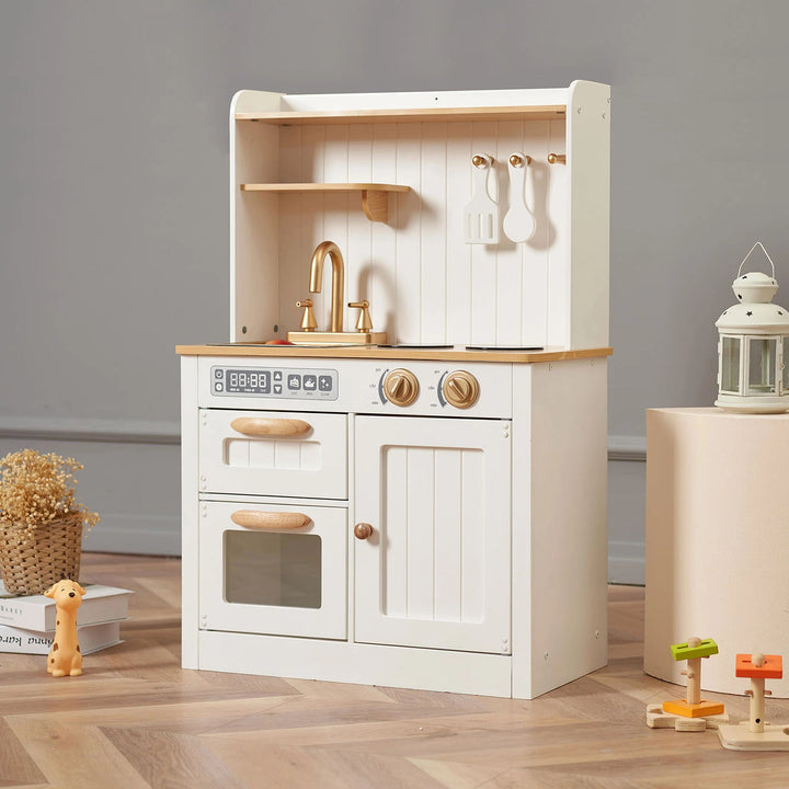A white wooden play kitchen with a stove, oven, sink, and a lantern on a wooden floor.