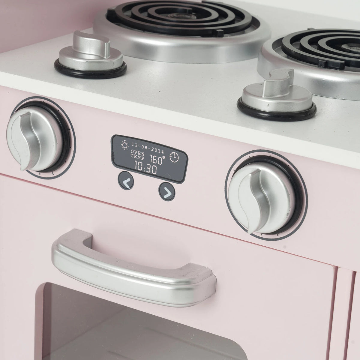 Close-up of a pink toy or play kitchen stove with silver dials, a black digital display, and a white stovetop surface.