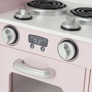 Close-up of a pink toy or play kitchen stove with silver dials, a black digital display, and a white stovetop surface.