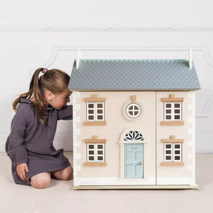 Girl is playing with the Large Wooden Dolls House