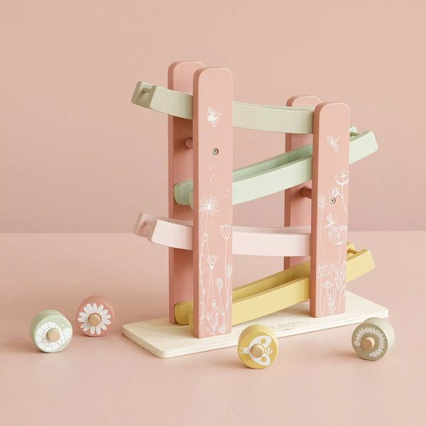 This is a flower-themed wooden ramp racer with four wheels that are decorated with flowers.