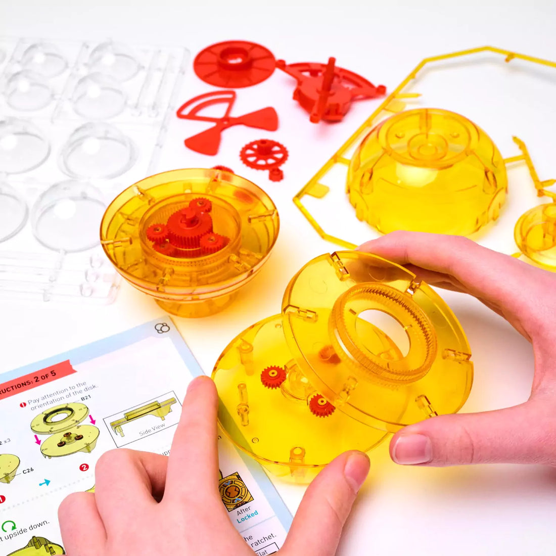 Child assembling a colorful solar system model with planets and gears