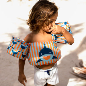 A kids wears a puddle jumper.