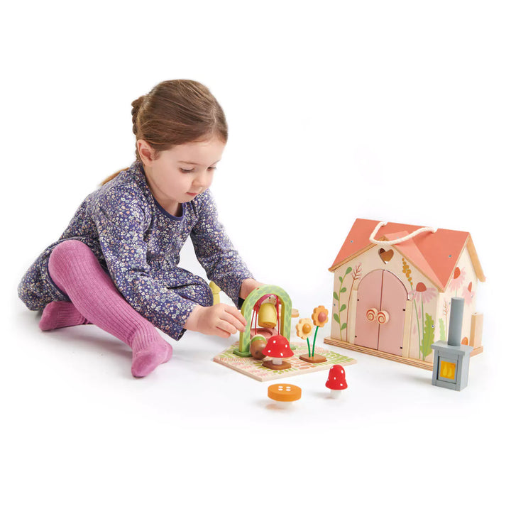 A girl is playing with rosewood cottage playset with accessories