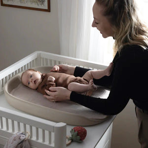The high, soft edge of the changing mat, designed to prevent rolling and provide added safety during nappy changes
