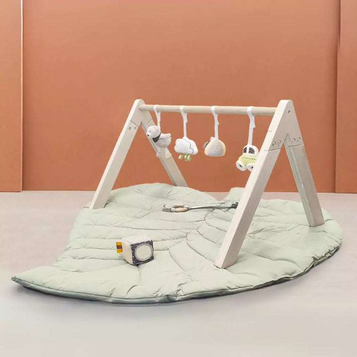 MiniDream Wooden Play Gym featuring a leaf playmat, hanging rattles, a sensory cube, and a teether, all made with eco-friendly materials.