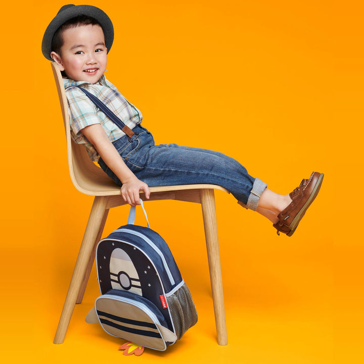 A boy is using a skip hop backpack