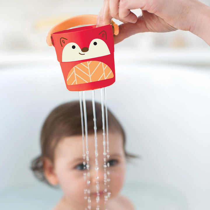 Child joyfully playing with baby bath toy Stack & Pour Buckets in bathtub