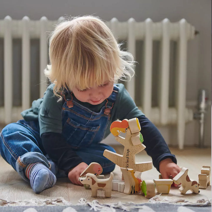A kid playing with stacking garden friends wooden toy