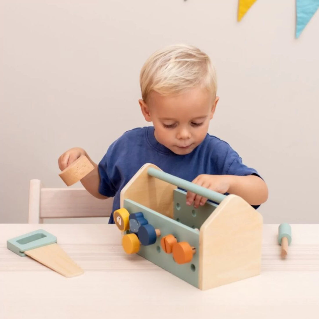 toddler boy playing with wooden tool set