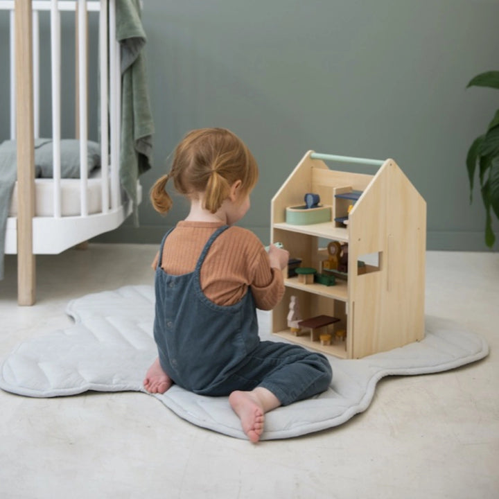 A girls is playing with doll house