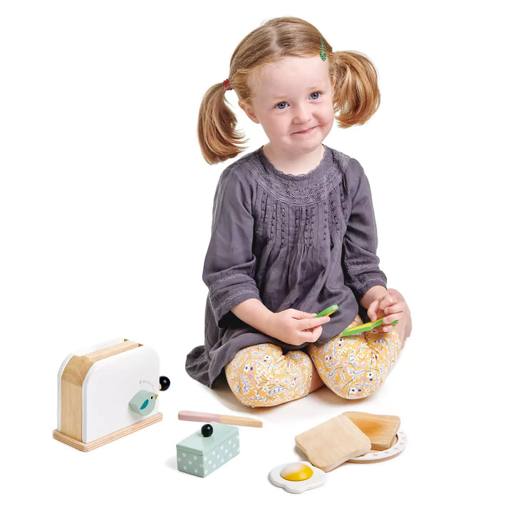 a girl playing with Wooden toaster breakfast set with poached egg and avocado