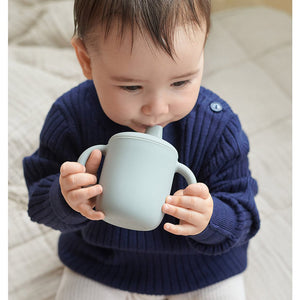 Baby drinking from Neil No Spill Silicone Sippy Cup from  Liewood