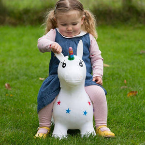 A toddler is playing with the Happy Hopperz Bouncy Kid's Ride Toy.