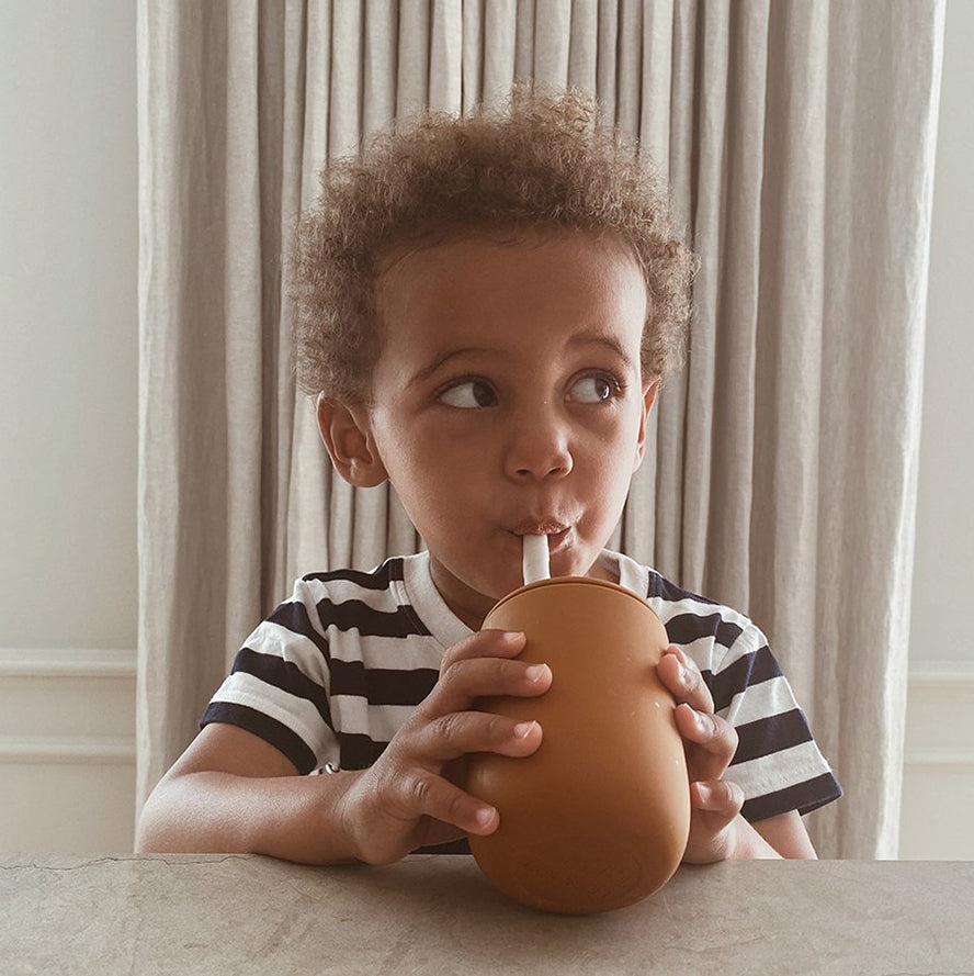 Boy drinking indepently with the liewood ellis silicon drinkware
